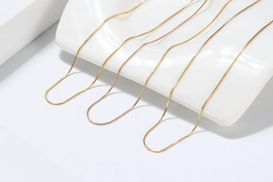 gold and rose gold chains on a white surface